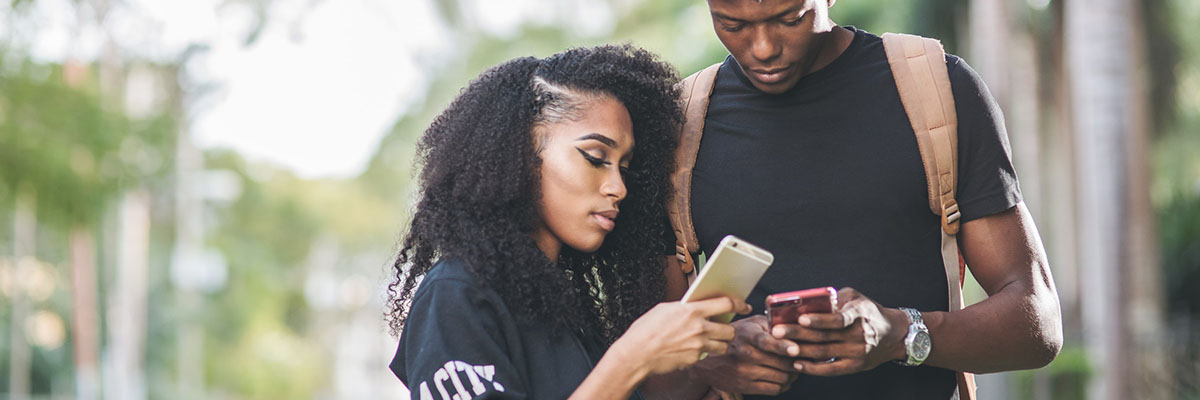 two young adults hold smartphones in their hands